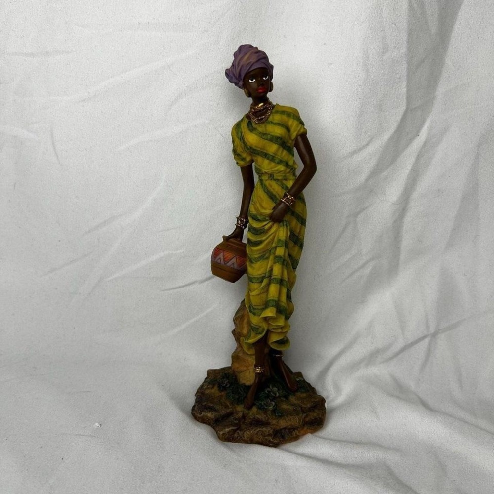 Beautiful woman figurine with clay pot, wearing gold jewelry and a head wrap